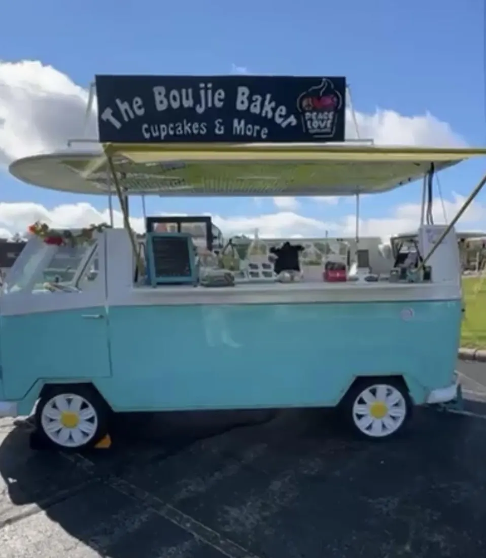 The Boujie Baker turquoise VW van with its 'The Boujie Baker – Cupcakes & More' sign